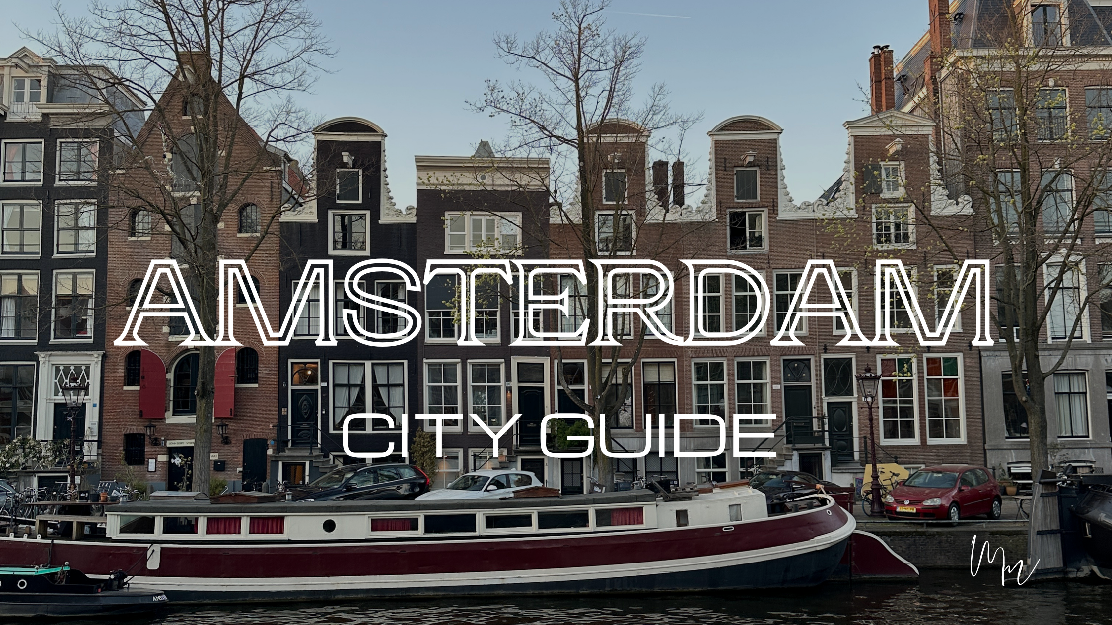 A view of traditional buildings beside a canal in Amsterdam with the title Amsterdam City Guide